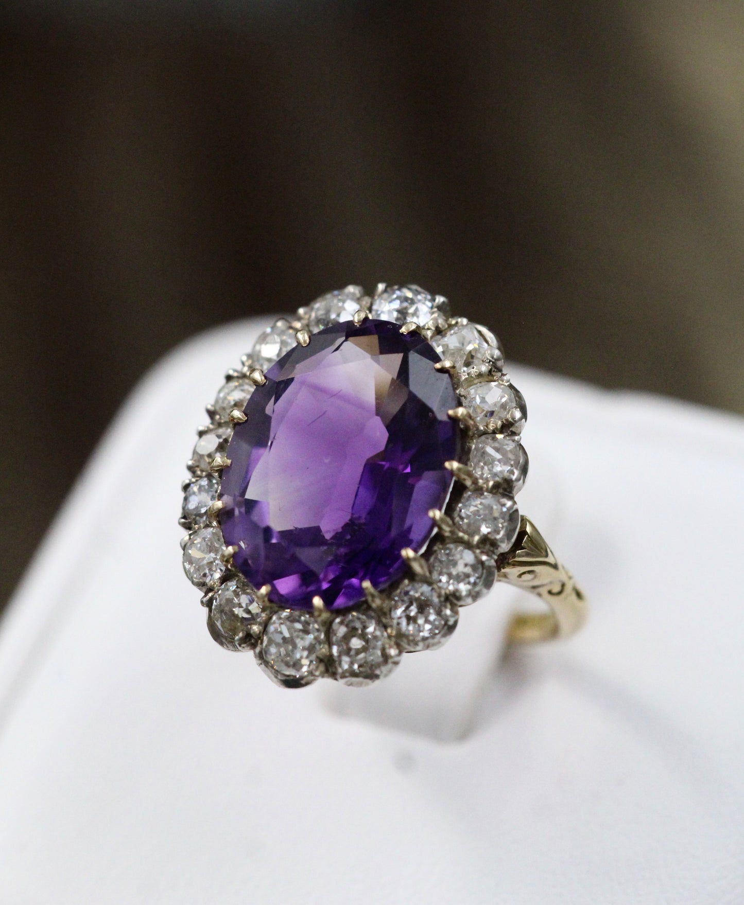 An Amethyst and Diamond Cluster Ring set with an Oval Amethyst, surrounded by 2.00 Carats of "Old Mine" Cut (Cushion), Shaped Diamonds, mounted in Silver on Gold, stamped 18 ct. Circa 1900. - Robin Haydock Antiques