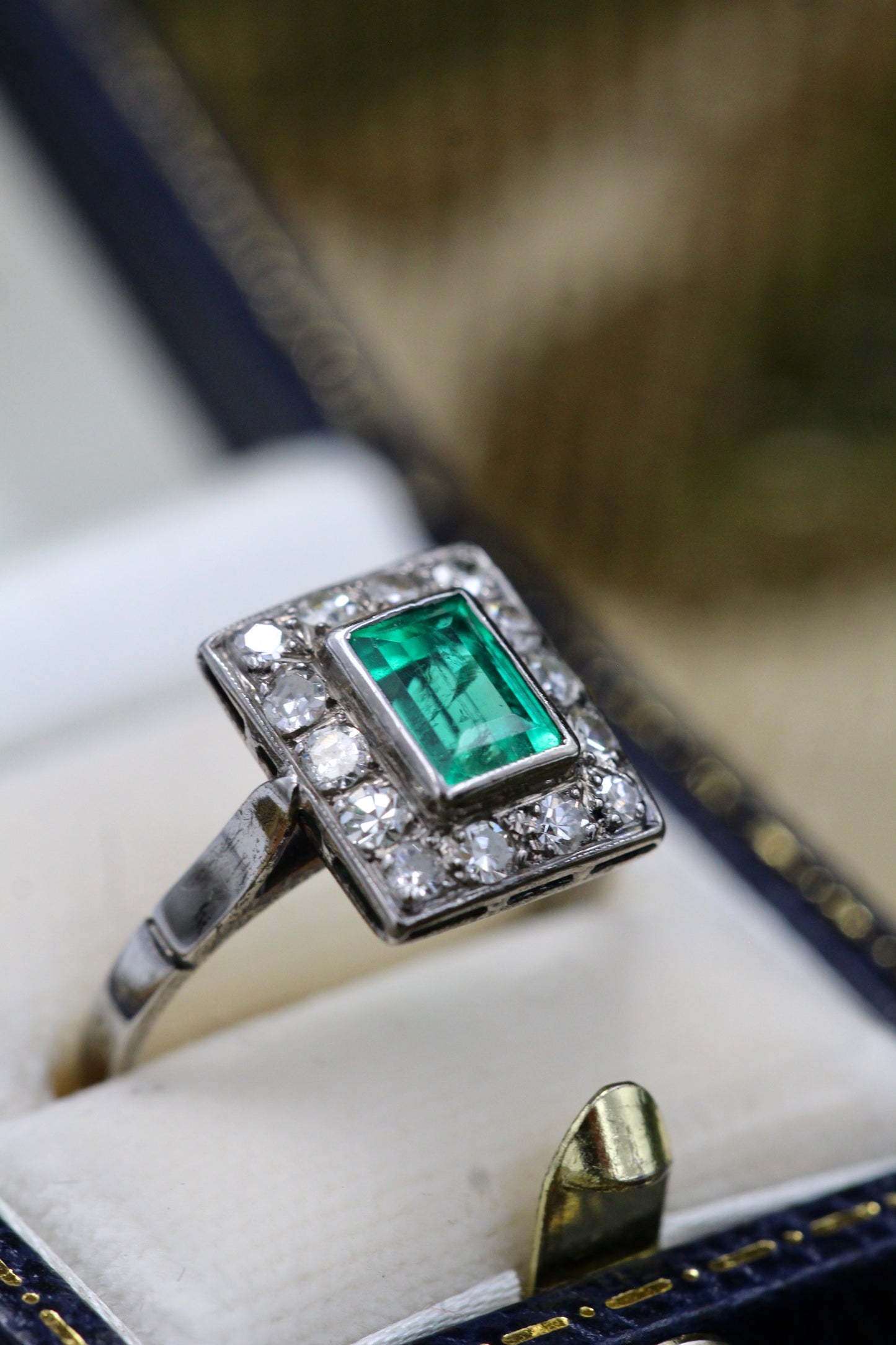 A very fine Platinum (tested) Cluster Ring set with a Modified Step Cut Emerald Certified as 1.10 carats "Colombian" (Moderate Oil), surrounded by gallery of fourteen Single Cut Diamonds. Circa 1930 - Robin Haydock Antiques