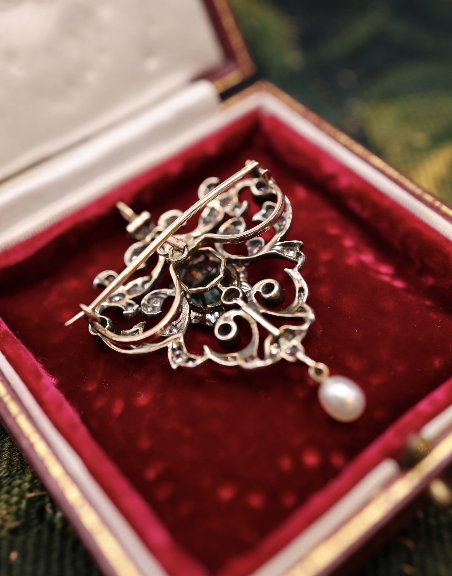 A very fine Antique Edwardian Pendant/Brooch, a central Emerald & Diamond Cluster within a foliate stylised Heart Shaped Diamond Set frame suspending a Pear shaped Natural Pearl. Circa 1890 - Robin Haydock Antiques