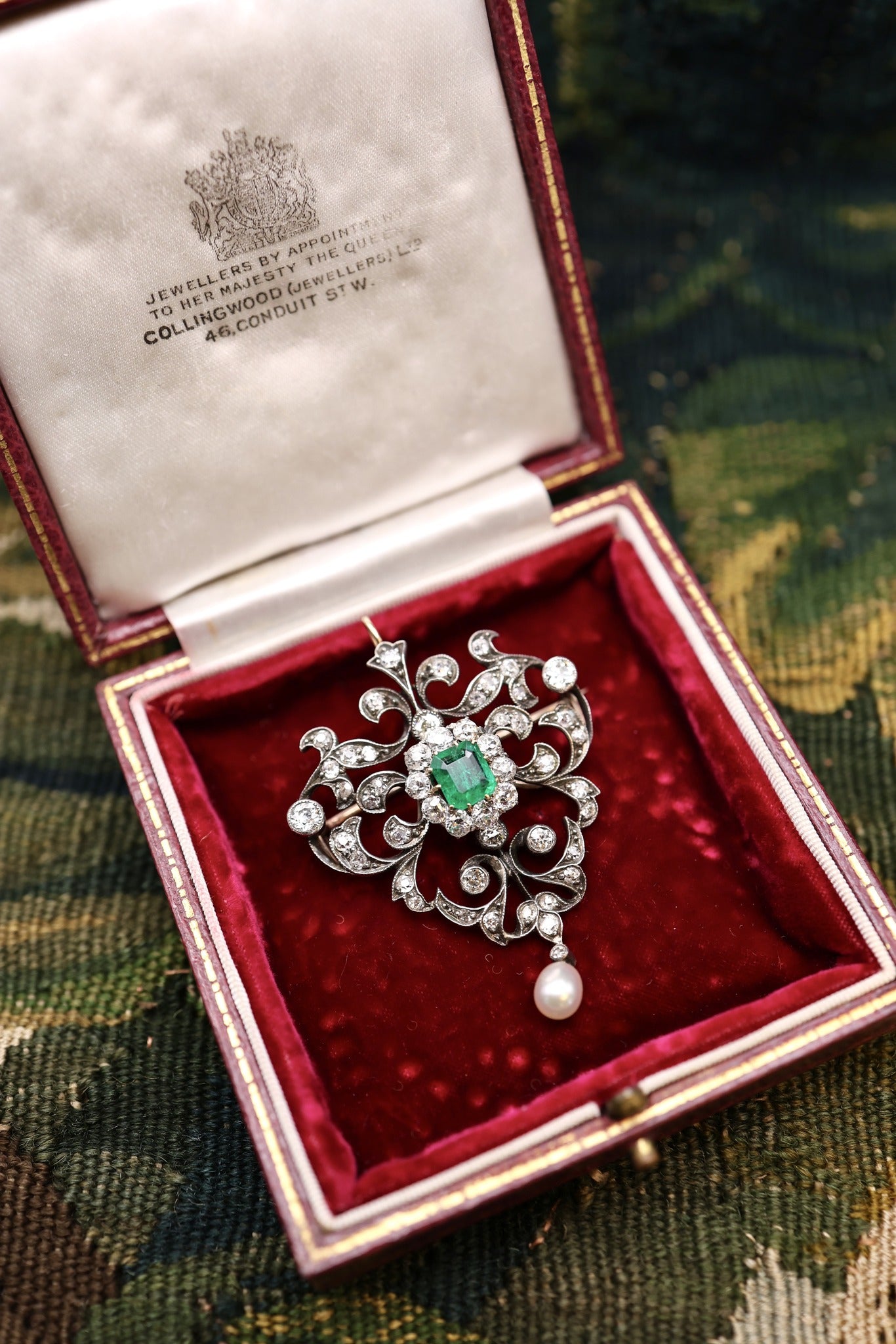 A very fine Antique Edwardian Pendant/Brooch, a central Emerald & Diamond Cluster within a foliate stylised Heart Shaped Diamond Set frame suspending a Pear shaped Natural Pearl. Circa 1890 - Robin Haydock Antiques
