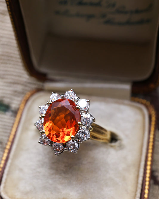 A very fine 18 Carat Yellow & White Gold Oval Fire Opal and Diamond Cluster Ring. London Hallmarks. Circa 1993.