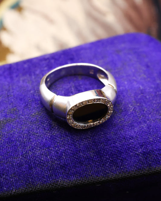 An 18ct (marked) Brushed White Gold Plaque Ring, with Oval Black Onyx, surrounded by a gallery of Single Cut Diamonds. Circa 1970 - Robin Haydock Antique Jewellery