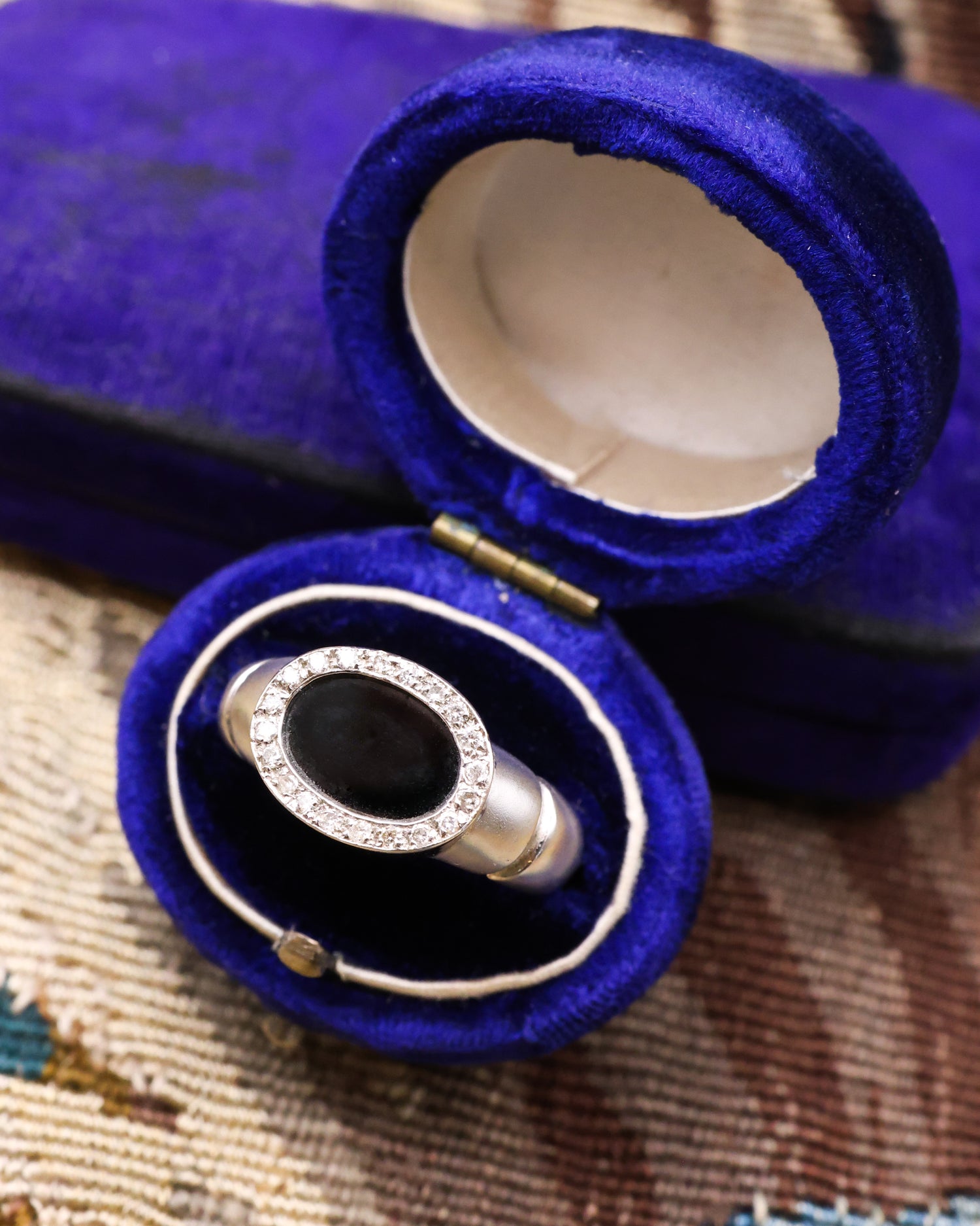 An 18ct (marked) Brushed White Gold Plaque Ring, with Oval Black Onyx, surrounded by a gallery of Single Cut Diamonds. Circa 1970 - Robin Haydock Antique Jewellery