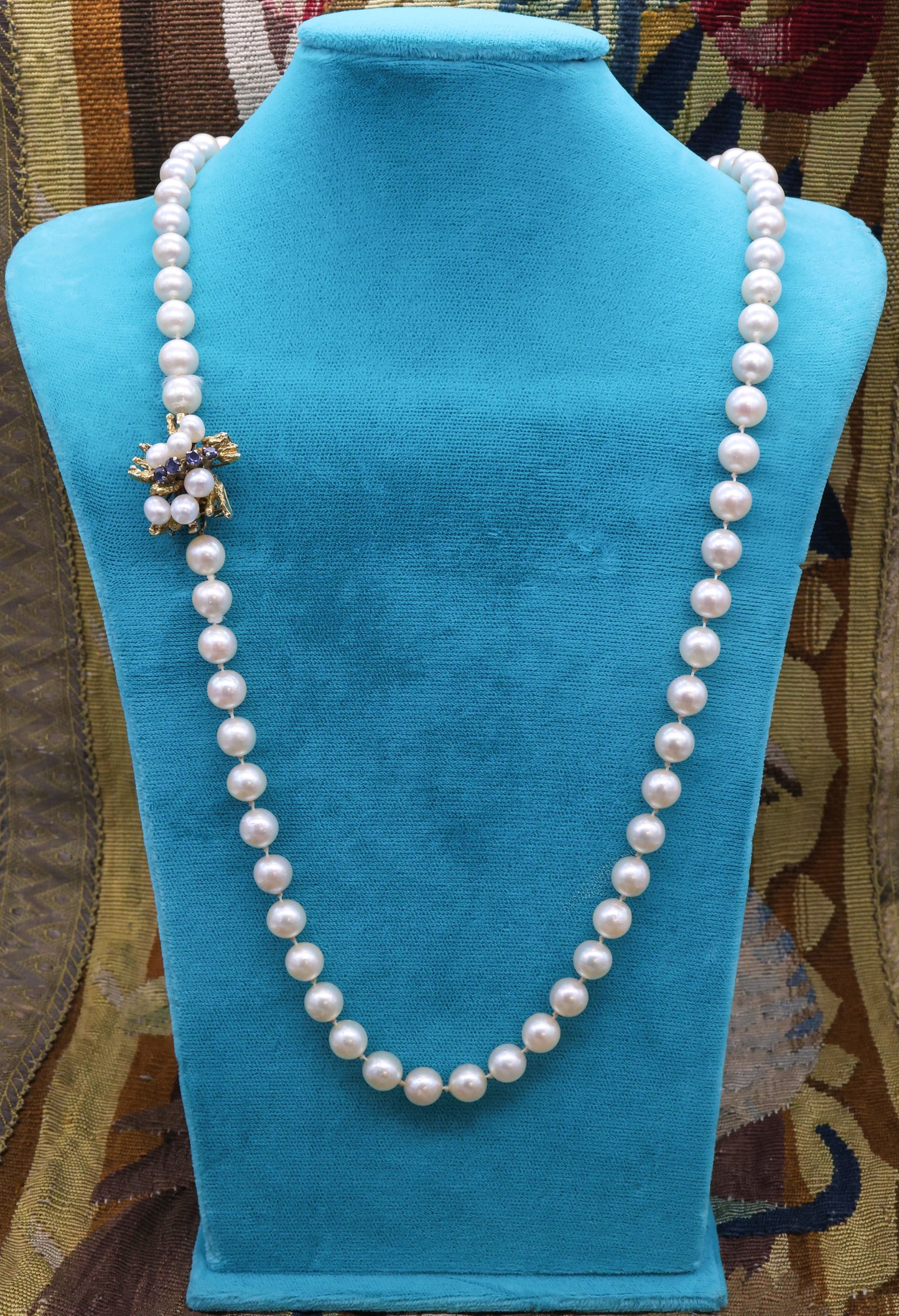 A fine Yellow Gold & Strung Cultured Pearl Necklace, set with four Round Cut Natural Sapphires (0.40 carats) and eighty three Oval and Near Shaped Cultured Pearls. Circa 1960