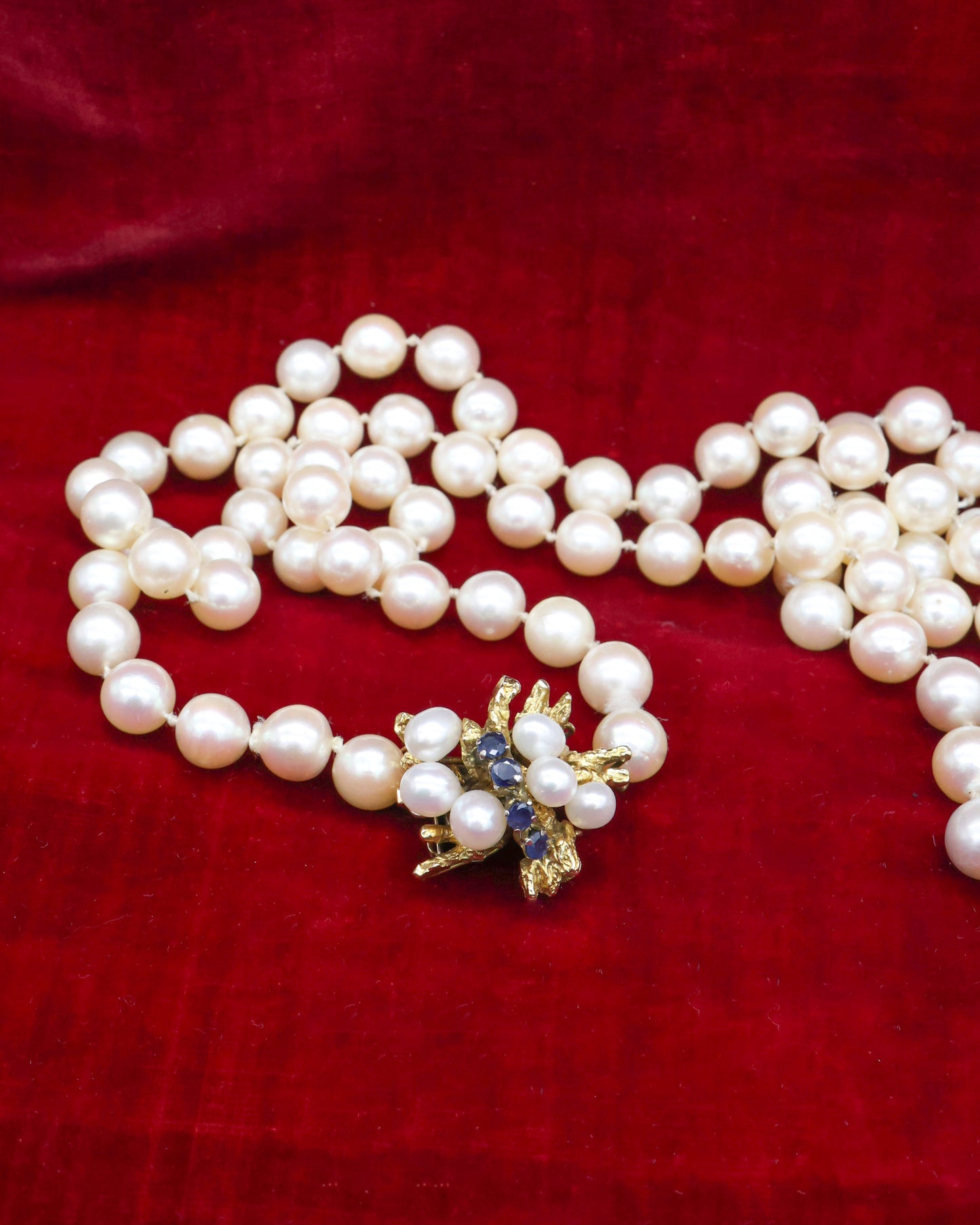 A fine Yellow Gold & Strung Cultured Pearl Necklace, set with four Round Cut Natural Sapphires (0.40 carats) and eighty three Oval and Near Shaped Cultured Pearls. Circa 1960