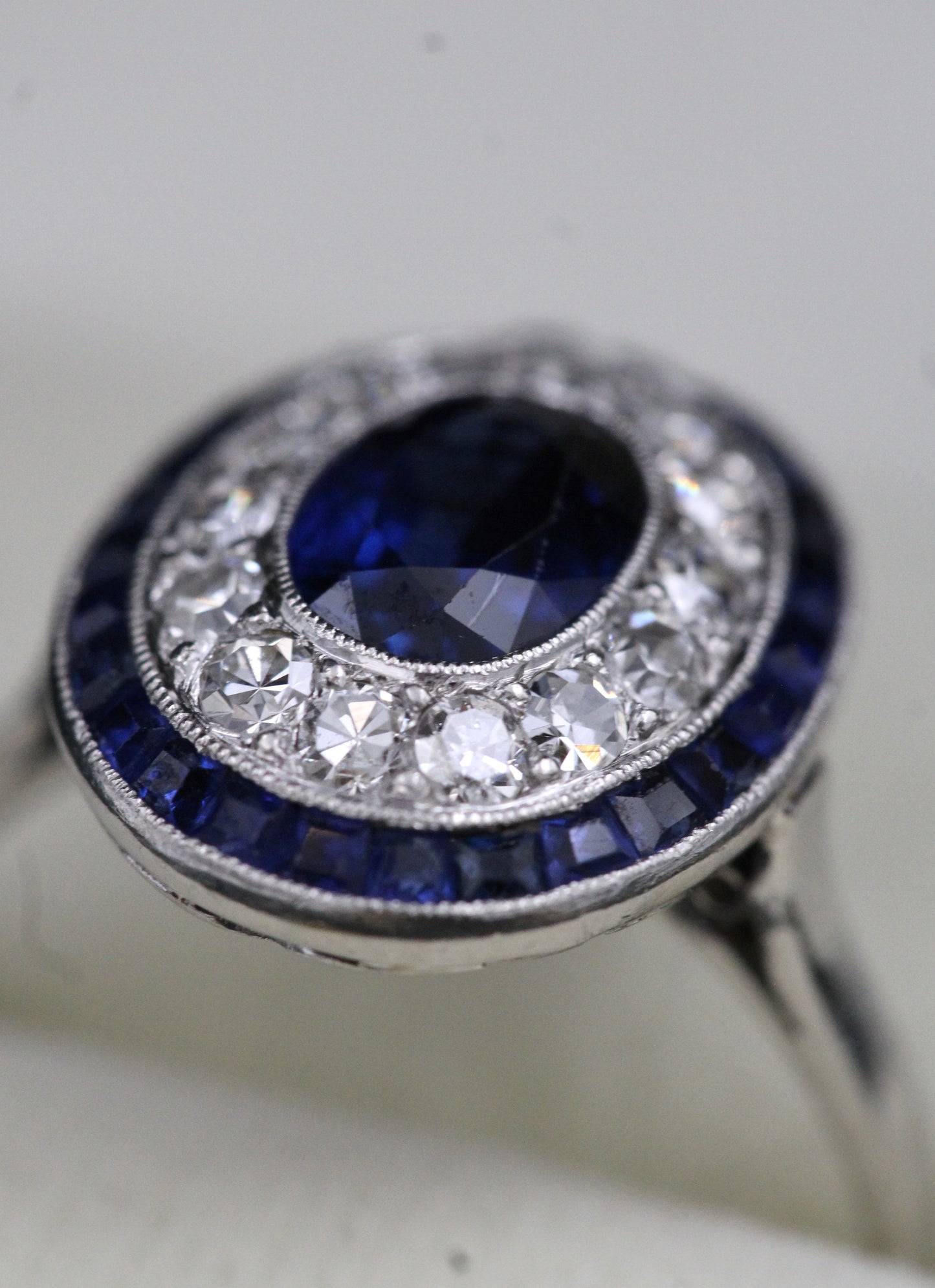 A very fine Platinum, Diamond & Sapphire Oval Target Ring, centrally Rub-over set with an Unheated Burma Sapphire. French. Circa 1930. - Robin Haydock Antiques