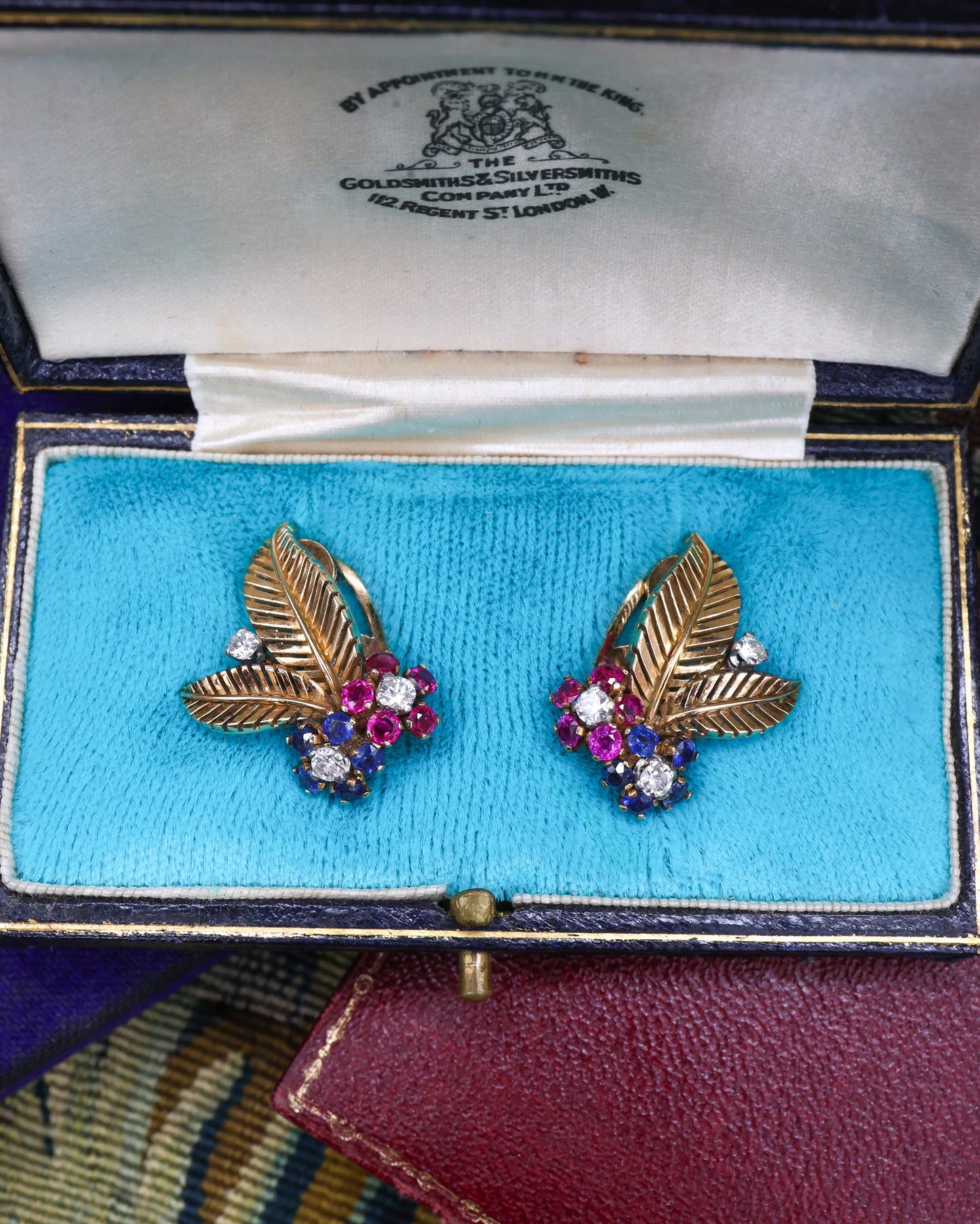A very fine pair of 18ct Yellow & White Gold (tested), Retro, Clip Earrings,  a Stylised Foliate Design set throughout with Diamonds, Burma Rubies & Sapphires. Circa 1940
