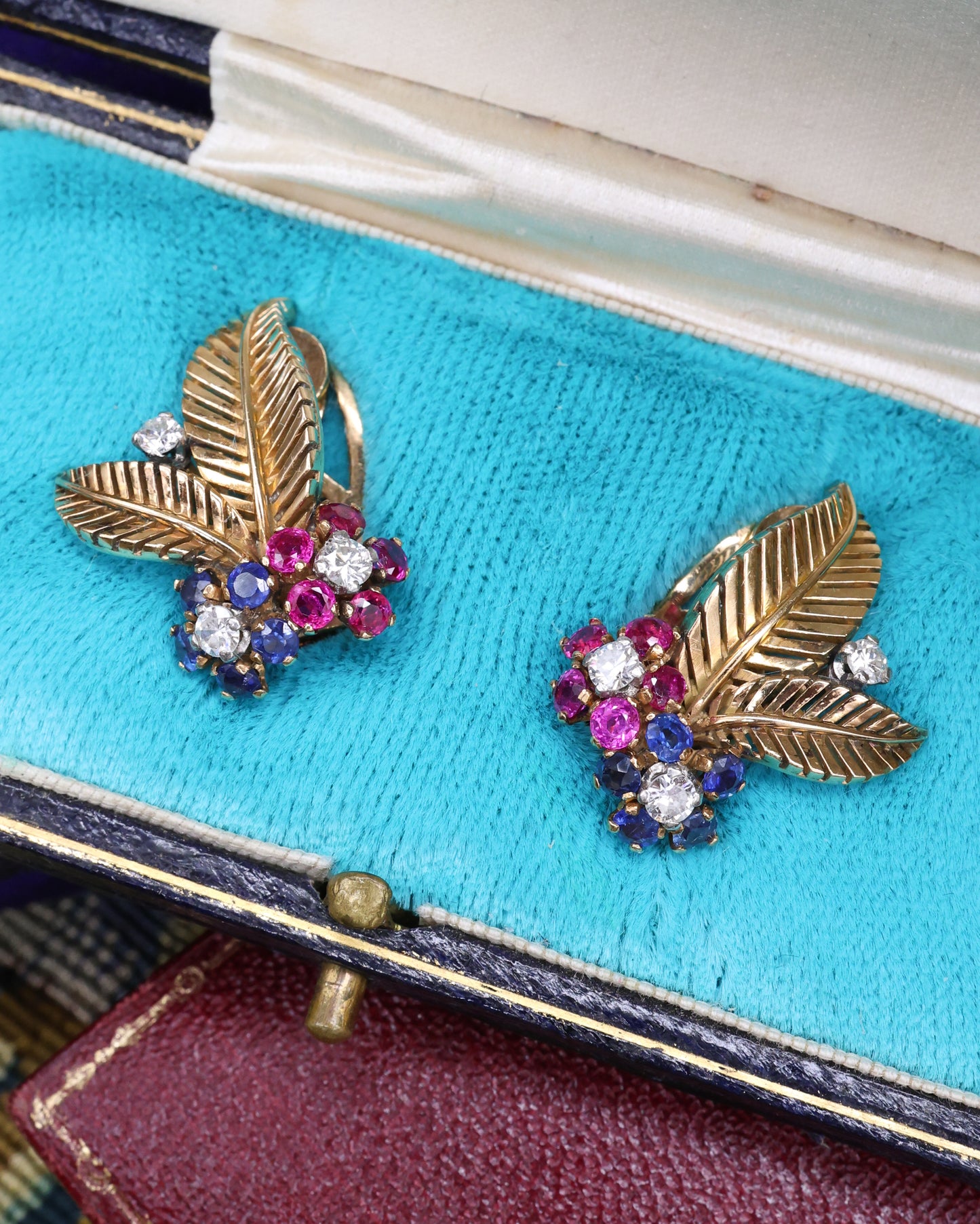 A very fine pair of 18ct Yellow & White Gold (tested), Retro, Clip Earrings,  a Stylised Foliate Design set throughout with Diamonds, Burma Rubies & Sapphires. Circa 1940