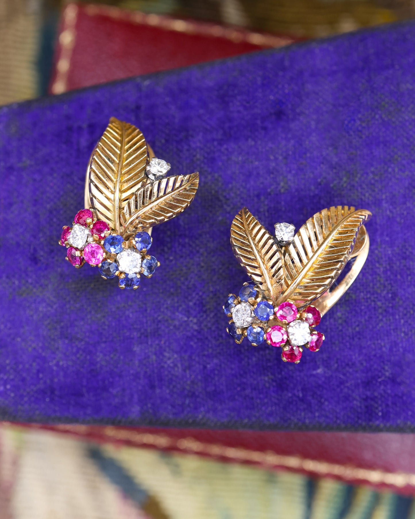 A very fine pair of 18ct Yellow & White Gold (tested), Retro, Clip Earrings,  a Stylised Foliate Design set throughout with Diamonds, Burma Rubies & Sapphires. Circa 1940