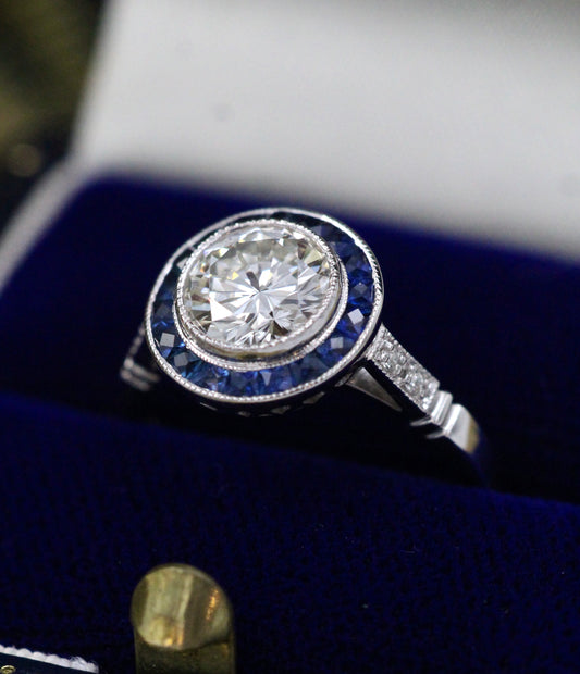 A very fine Platinum, Diamond & Sapphire Oval Target Ring, centrally Rub-over set with an Unheated Burma Sapphire. French. Circa 1930. - Robin Haydock Antiques