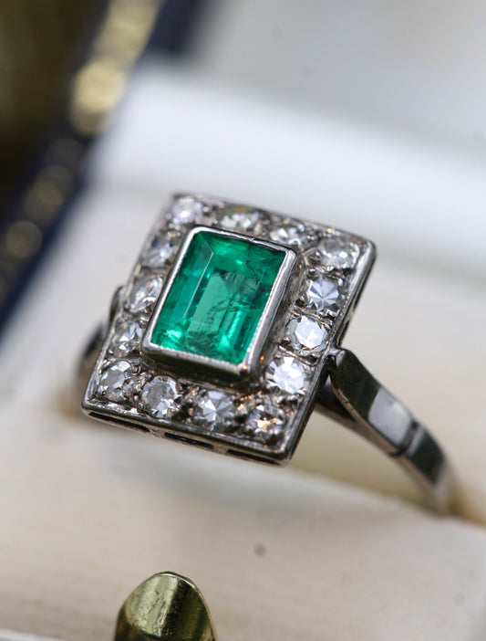 A very fine Platinum (tested) Cluster Ring set with a Modified Step Cut Emerald Certified as 1.10 carats "Colombian" (Moderate Oil), surrounded by gallery of fourteen Single Cut Diamonds. Circa 1930 - Robin Haydock Antiques