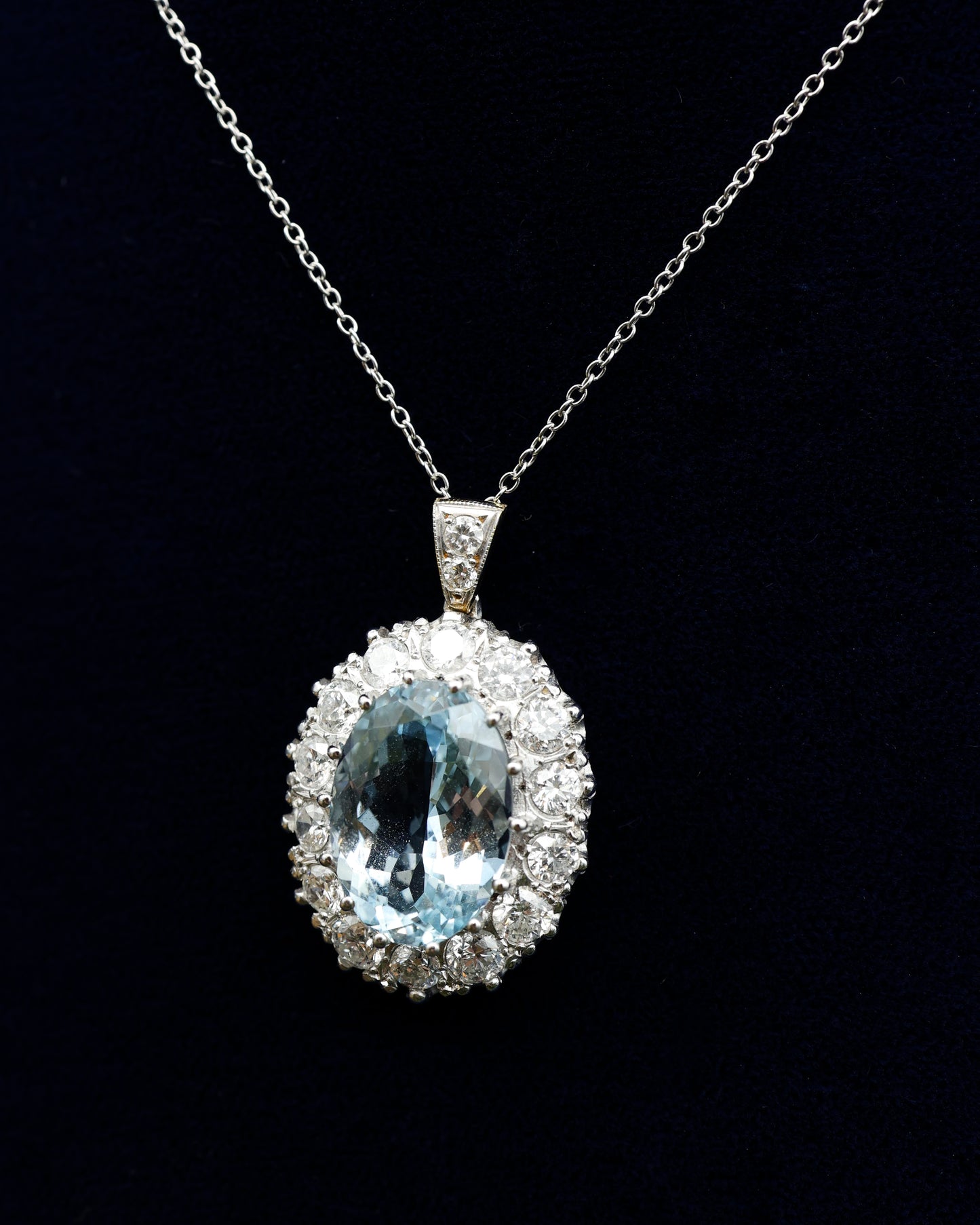 A fine 18 ct. White & Yellow Gold (tested) Oval Aquamarine and Diamond Cluster Pendant. Mid - Late 20th Century.
