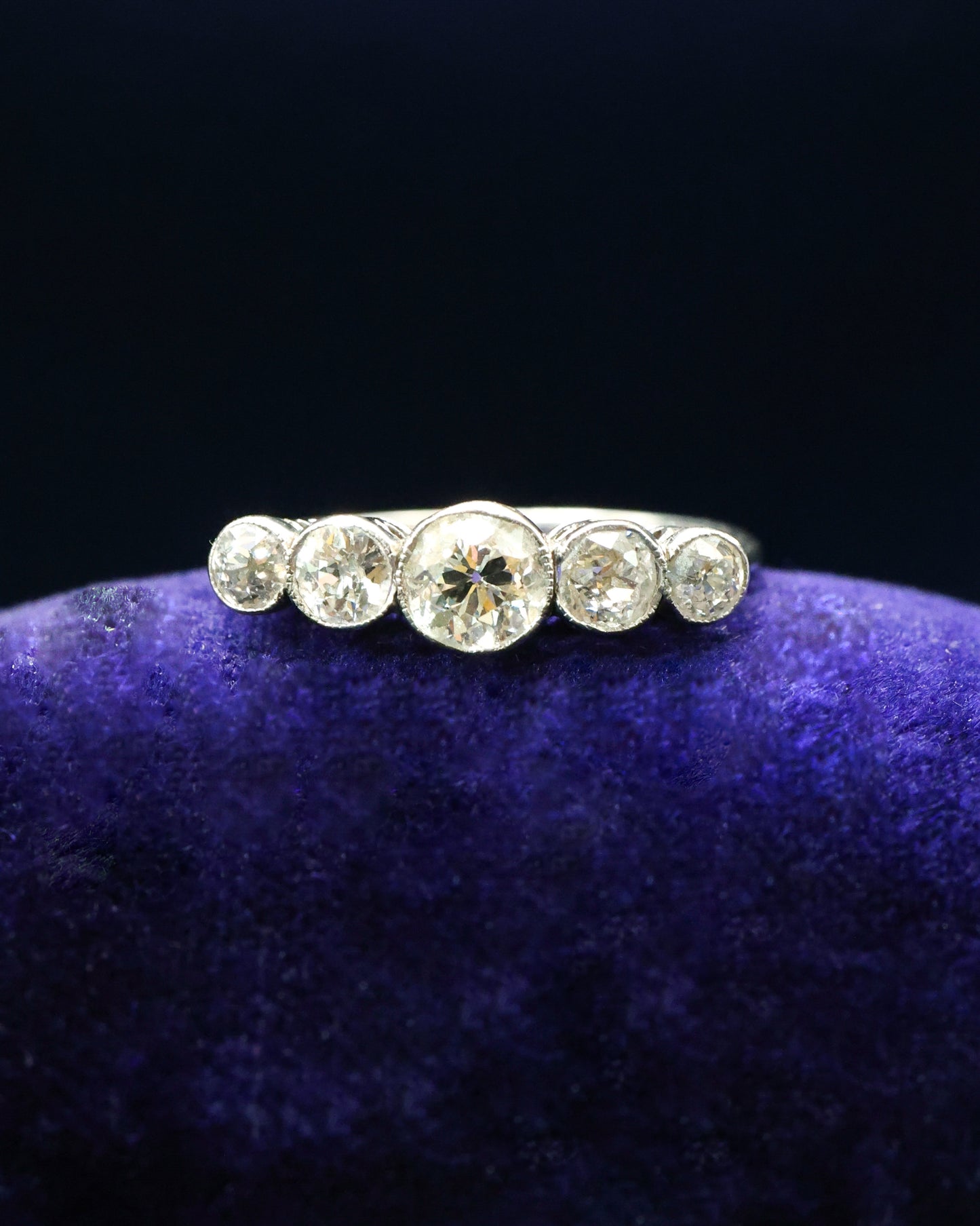 A very fine 18ct. White Gold (later rhodium plated), graduating five stone Diamond Ring, rub-over and granulated set with five Old European Cut, Natural Diamonds. Circa 1930
