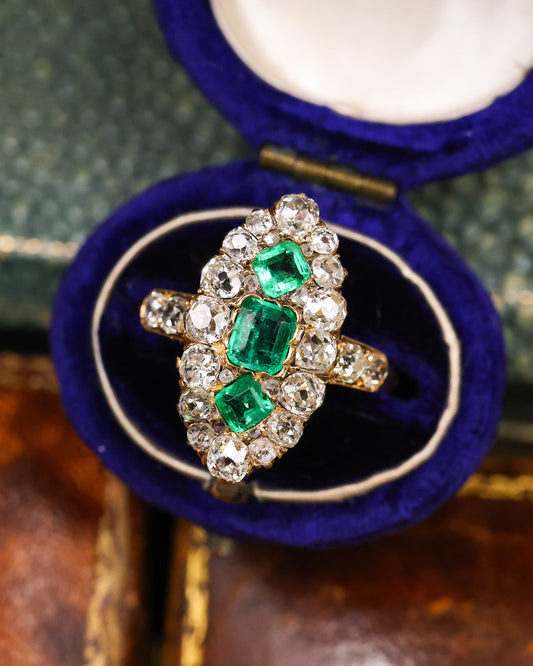 A very fine antique 18 ct. Yellow Gold (tested),  Navette shaped ring set with three Octagonal Step Cut Natural Emeralds & numerous Diamonds, with Diamond set shoulders. English. Circa 1870.